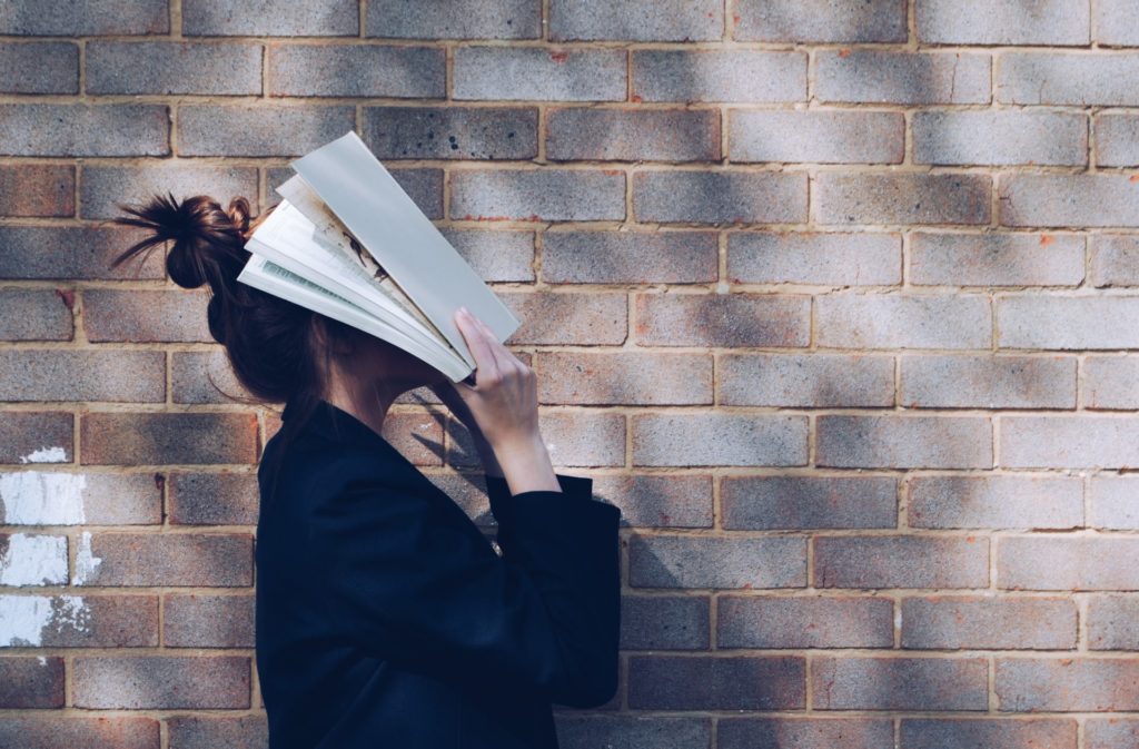 Person trying to read, but with book on their face